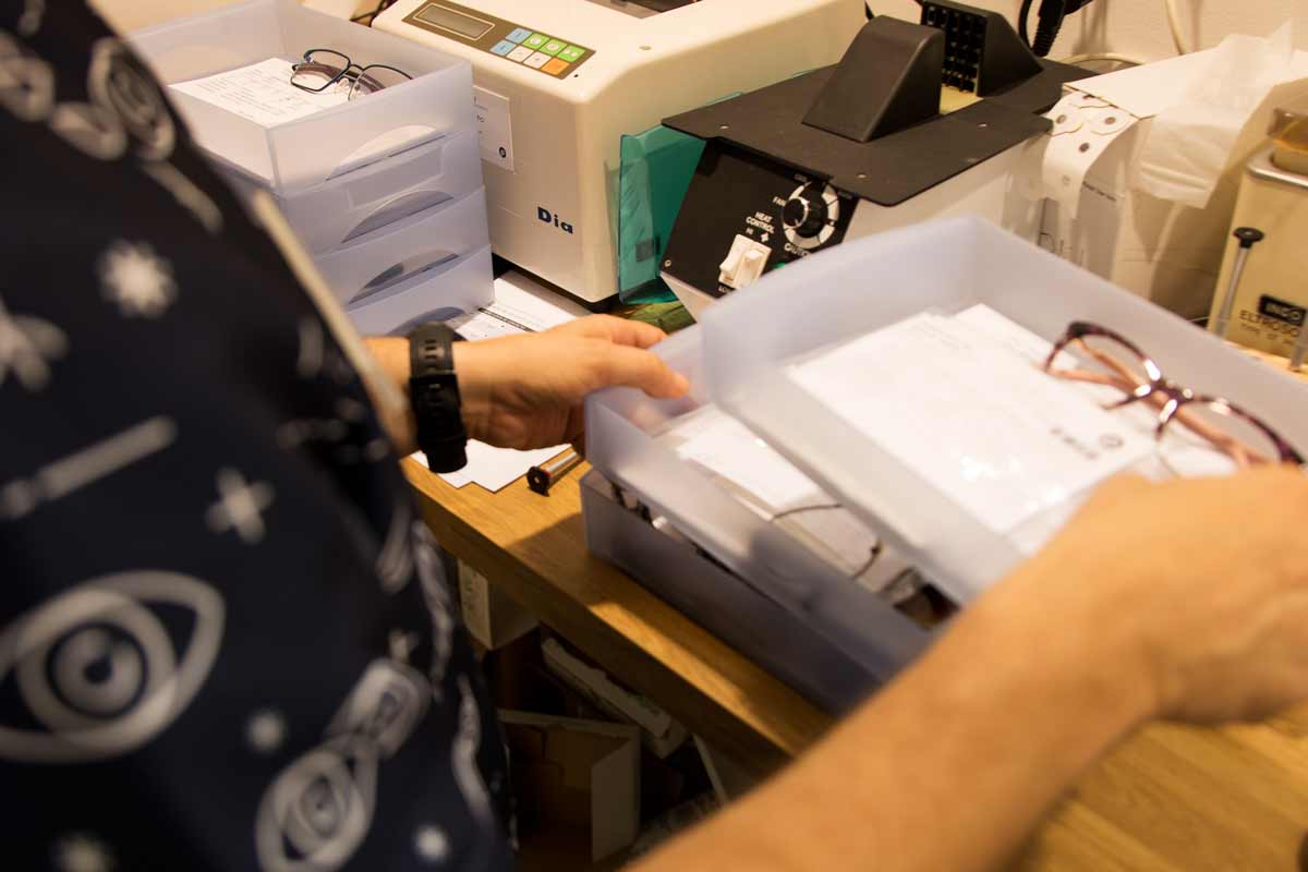 Mans agafant diferents separadors on a dins té papers i ulleres